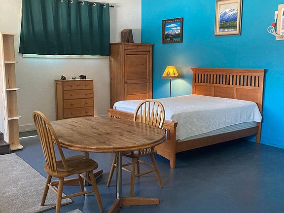 The bedroom area is divided by the "dining room" area