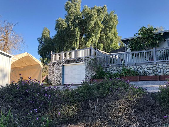 Front of house showing single car garage and carport.