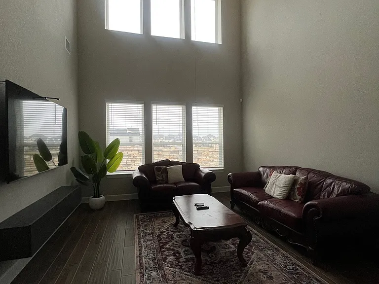 Bright, spacious living room with soaring ceilings and abundant natural light_perfect for relaxing or entertaining with plenty of room to gather.