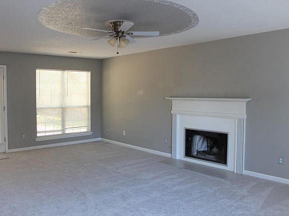 Great room with ceiling fan and fire place