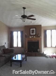 living room : vaulted ceiling with lighted ceilingfan ,gas fireplace, with plenty of light.