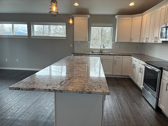 Beautiful quartz counters for dining and entertaining with stainless steel appliances and fridge