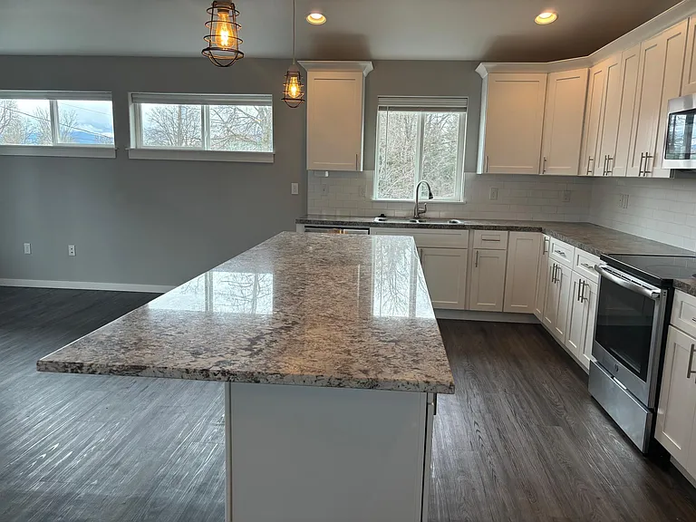 Beautiful quartz counters for dining and entertaining with stainless steel appliances and fridge