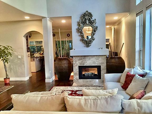 Living room with dual sided fireplace. High vaulted ceilings and lots of windows!