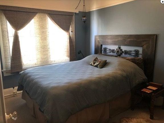 Bedroom with room for queen or king bed, large windows, custom blinds and soothing blue accent walls