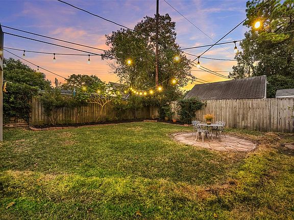 Spacious backyard has generous sized grass area; wonderful for pets, children, or entertaining! Sellers recently had waste water line replaced (Nov 2020) which is noticable and should diminish soon. Stairs seen on left lead up to Studio room over gar