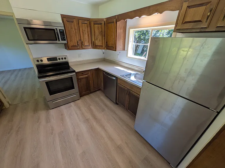 kitchen with dishwasher, glass top range, refrigerator with ice maker