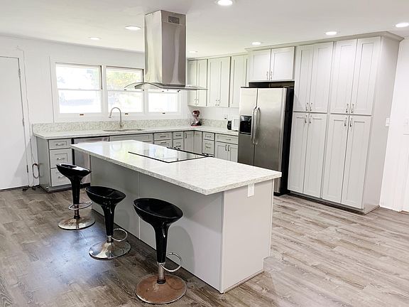 Completely updated kitchen with wide central island with bar seating, quartz countertops, pull-down kitchen faucet, can lights, floor-to-ceiling soft-close pantry cabinets, all stainless steel appliances (brand-new dishwasher). Absolutely designed and cre