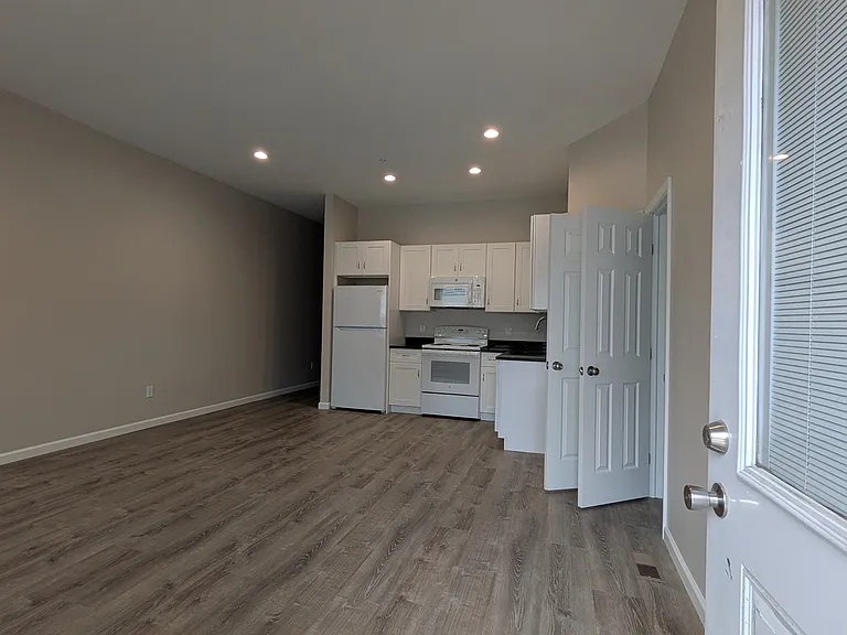 Front entry that leads to the living room, dining room, and kitchen