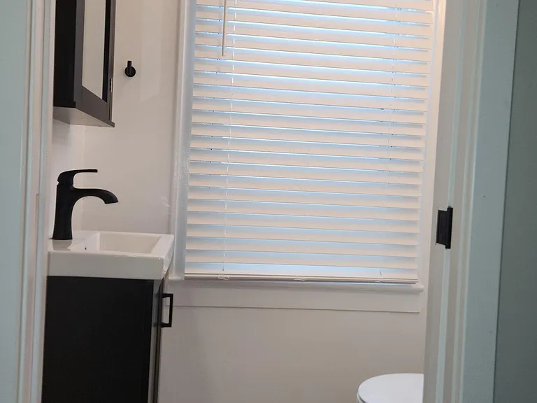 New downstairs half-bath, pocket door, two lights, one window, new luxury vinyl floor
