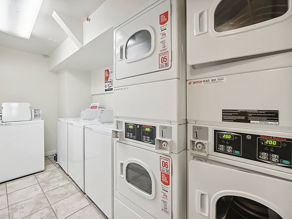 Laundry room with washing machines neatly arranged on a wooden floor