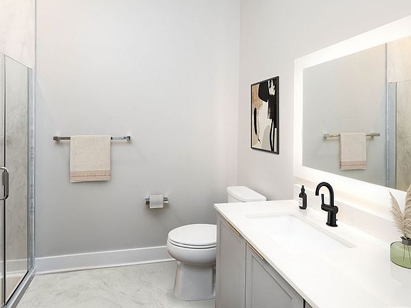 Signature Collection bath with white quartz countertop, grey cabinetry, and marble quartz bath surround (Representative photo)