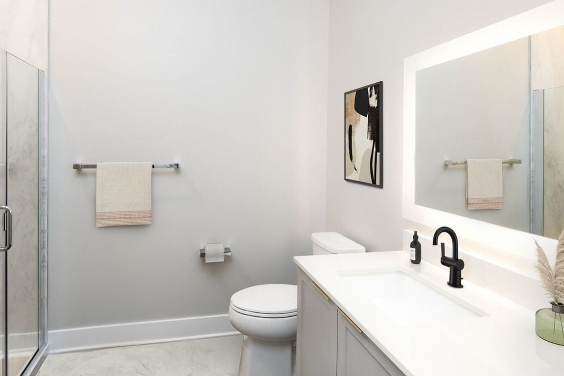 Signature Collection bath with white quartz countertop, grey cabinetry, and marble quartz bath surround (Representative photo)