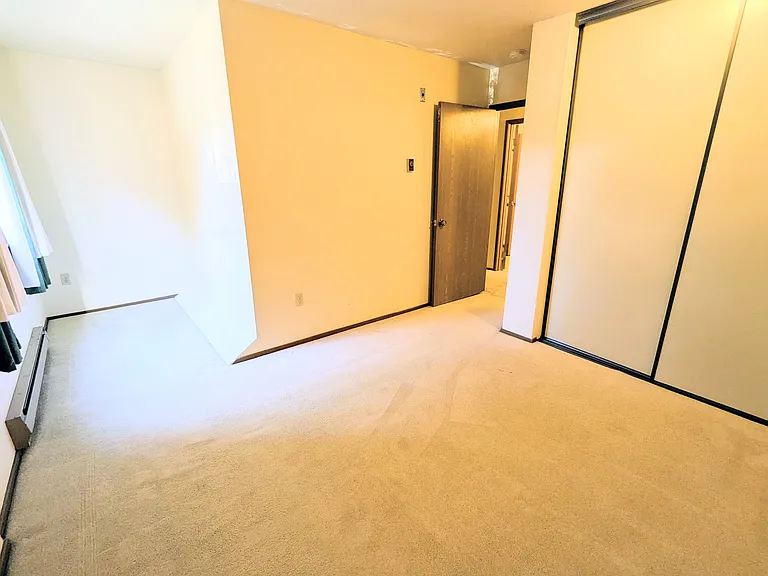 Bedroom with large closet and desk/storage nook in front of the window