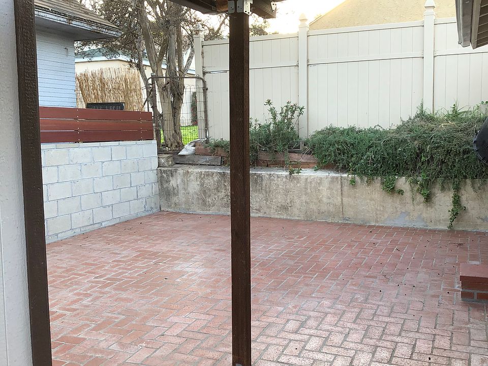 As you walk down the walk way you come to your patio. Potted plants in the far corner now.