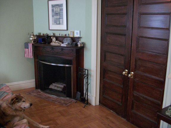 Back parlor with original sliding doors and another fireplace