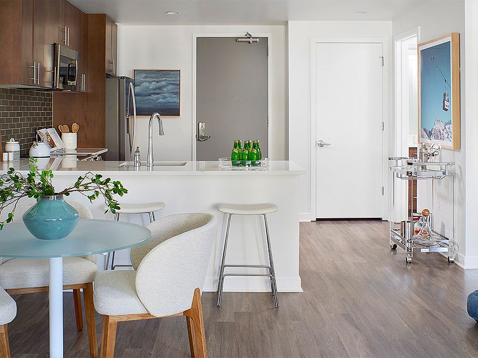 Apartment kitchen and dining room with wood-style flooring.