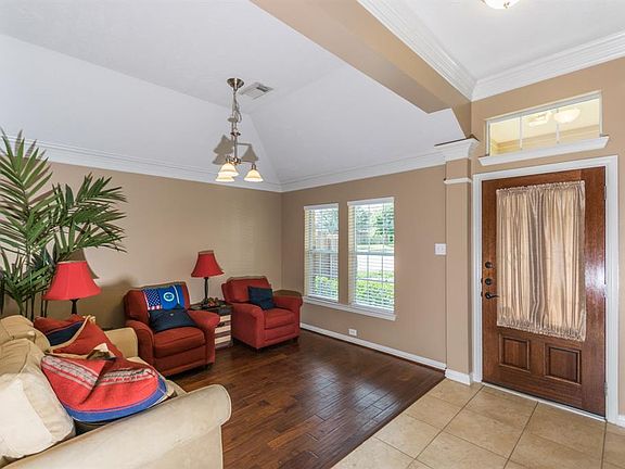 Foyer with crown molding open to den or dining room.