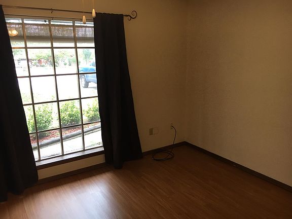 front room with view of driveway . The floor is a vinyl plank flooring , which is in most of the house.