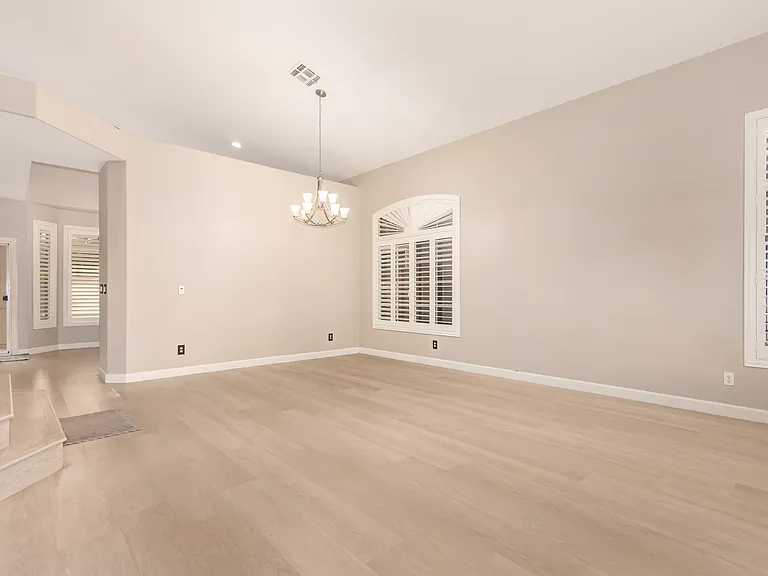 Bright Living Room with Large Windows, Wood Shutters, and an Formal Dining Area.