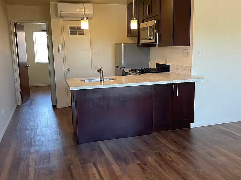 Breakfast bar with quartzite countertop and pendant lighting. Quiet, mini split ac/heating for kitchen and living room.