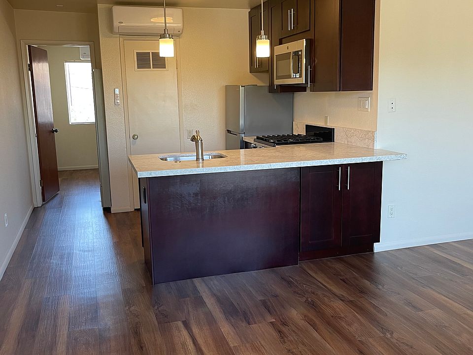 Breakfast bar with quartzite countertop and pendant lighting. Quiet, mini split ac/heating for kitchen and living room.