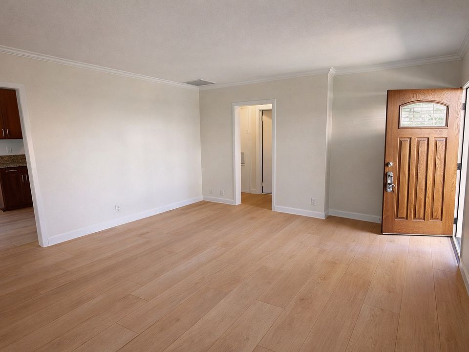 View of living room with front door on the RT. The kitchen is located to the Left of the photo