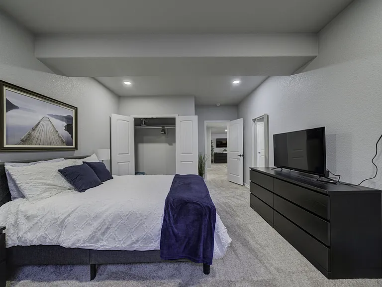 Queen Bedroom
Downstairs bedroom with queen bed, smart TV, two armchairs, dresser, and closet