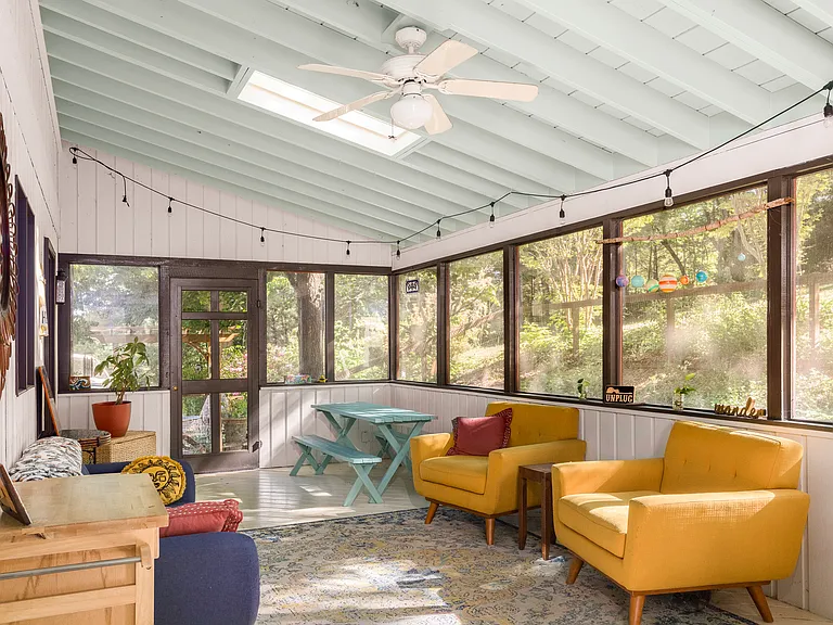 Dreamy, enclosed back porch perfect for dining, extra living space and hosting.