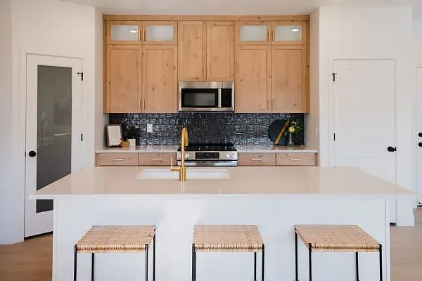 Staged photo. Condo has white cabinets with black hardware.