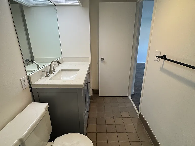 Recently updated bathroom features new tile, updated vanity, and bright lighting.