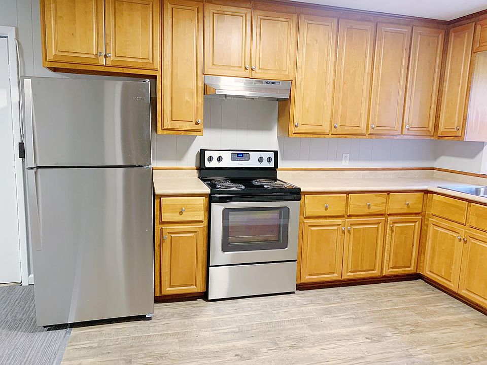Kitchen with new stainless steel appliances. Window looks onto back porch and large backyard surrounded by woods.