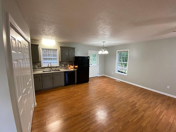 Open living area with kitchen, laundry closet, and private back deck access.