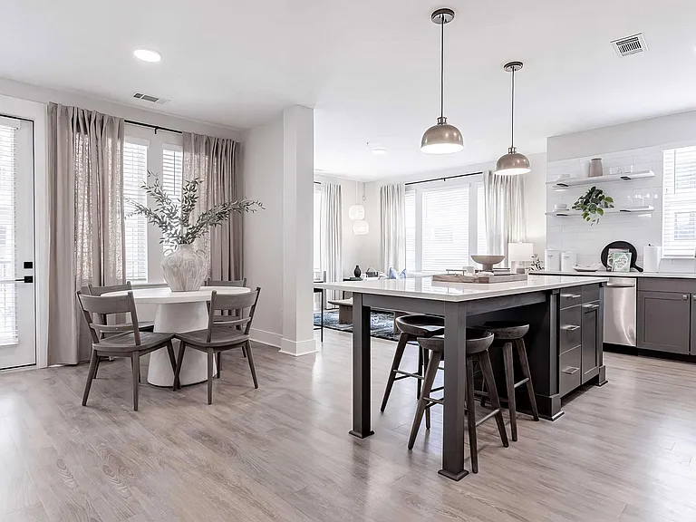 Bright kitchen area with dark wood accents and white countertops