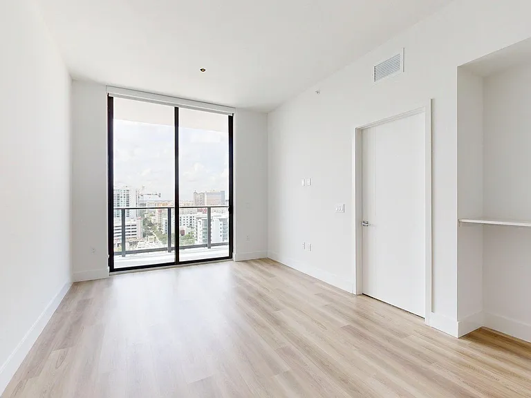 Apartment living room with wood-style flooring and balcony.