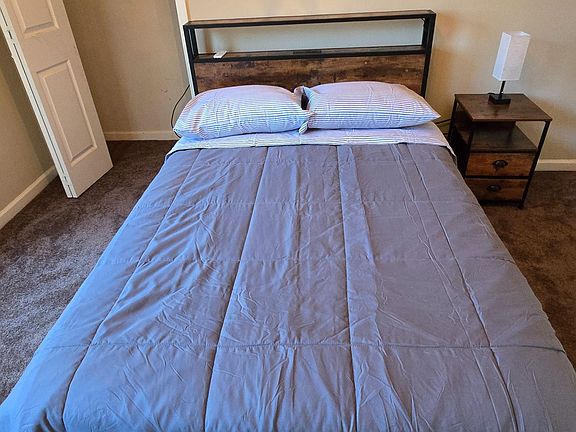 Cozy room with closet space and additional charging ports and LED lighting on nightstand and bedframe.
