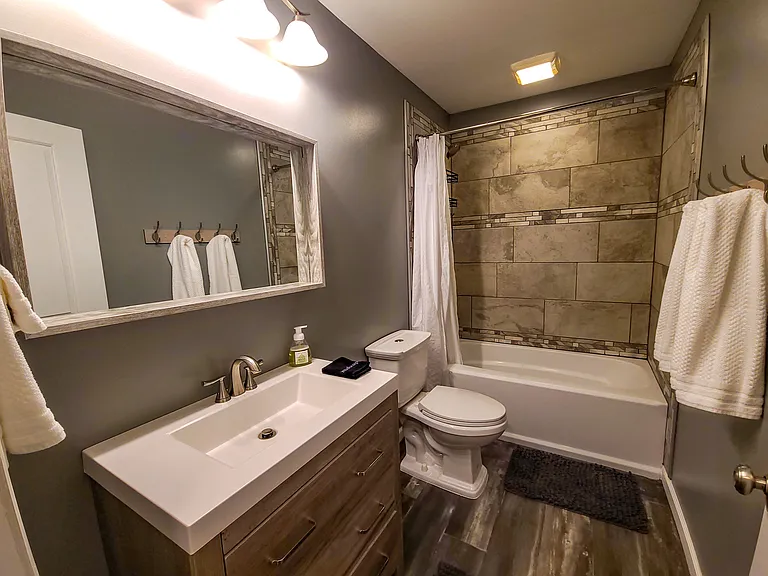 Private guest suite with bathtub and tiled shower and floor.