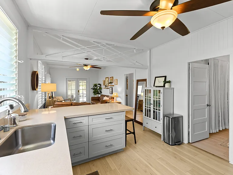The kitchen is open to the living room and features plenty of storage and counter space, a ceiling fan, full size refrigerator with water station, oven, microwave and dishwasher. The kitchen is fully equipped.