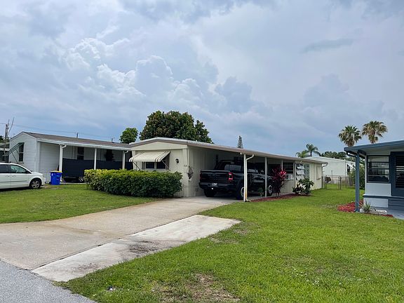 Carport with attached florida room with attached shed with washer and dryer in it.
