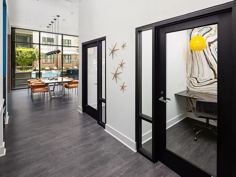 Glass-Enclosed Private Workspaces with View into Poolside Meeting Area