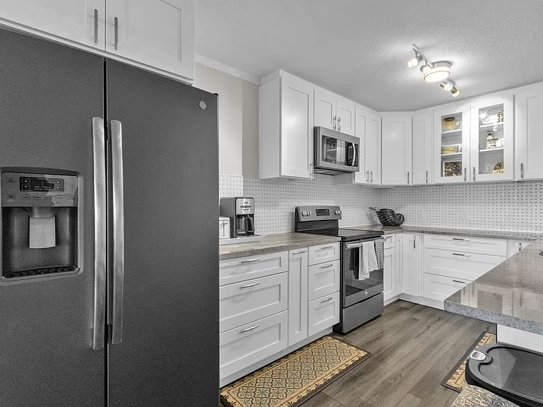 Beautifully, upgraded kitchen, white cabinetry, tiled backsplash and stainless appliances