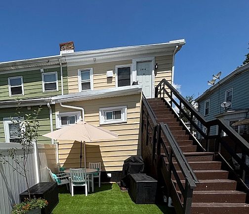 The private entrance steps lead you to your new home, showcasing the dedicated dining, grilling, and playing no-maintenance lawn area.