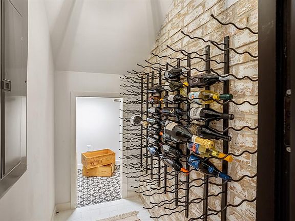 Vintage view wall wine rack mounted on brick wall. Notice the custom tile floors.