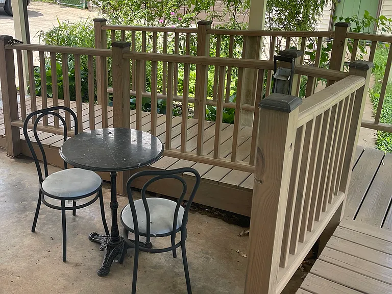 Covered patio area behind the house. Ramp leading down from the back door.