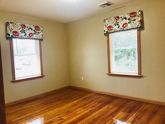 Bright and sunny living room with fresh paint and newly refinished flooring.