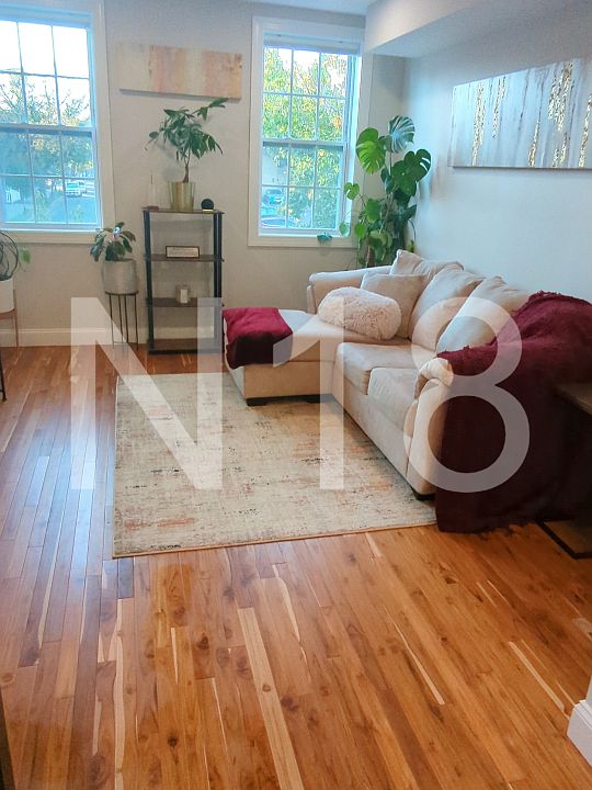 Living room on main level with plenty of natural light and blackout electric blinds