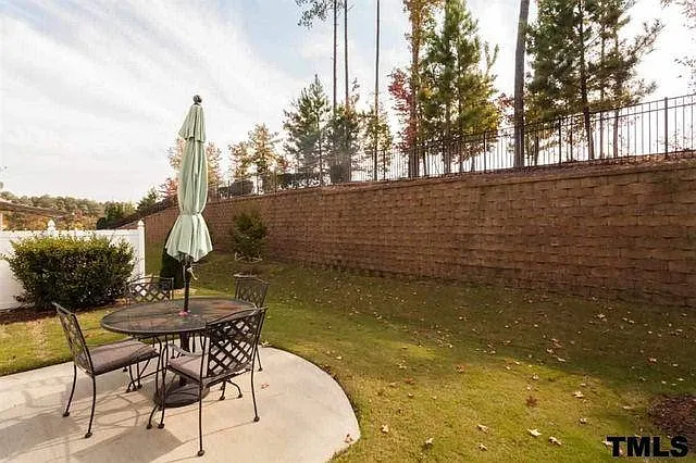 Backyard with tall stone wall and half fence for privacy on the patio