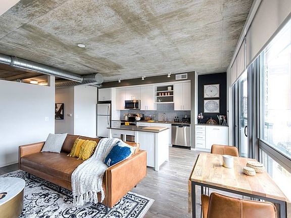 Open concept kitchen and living areas with hard surface flooring and floor to ceiling windows