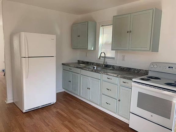 Kitchen with Stove and Refrigerator. Stainless steel sink and faucet