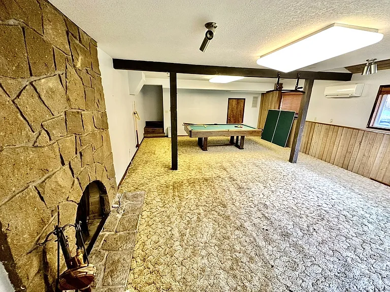 Fully finished walkout basement with rock wall fireplace & sliding glass door leading out to the lower yard. Pool table/ping pong table stays with house.